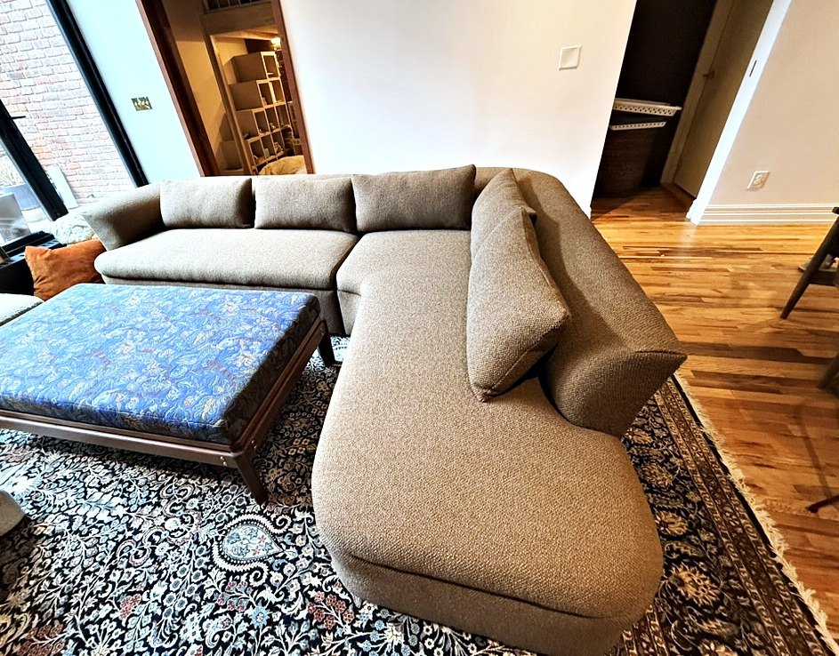 Custom-built curved sectional sofa with a custom blue fabric ottoman