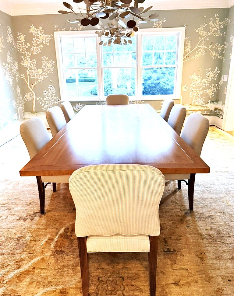 Upholstered dining chairs in a striped fabric around a long wood dining table